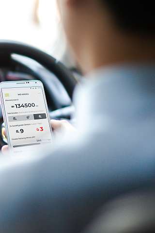 Foto von Fahrer mit Fahrtenbuch App zur Erfassung der Fahrt im elektronischen Fahrtenbuch