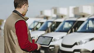 Fleet manager with fuel efficiency dashboard on tablet