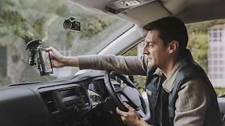 Van driver looks at a Webfleet device