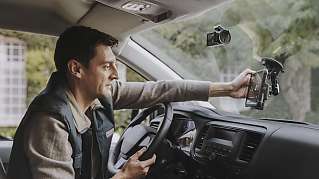 Een wagen­be­stuurder bekijkt zijn tablet