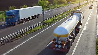 Vracht­wagens en auto's op een snelweg