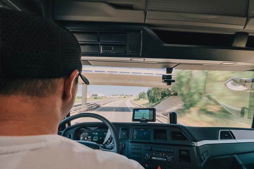 Lkw-Fahrer sitzt am Steuer und fährt auf der Autobahn