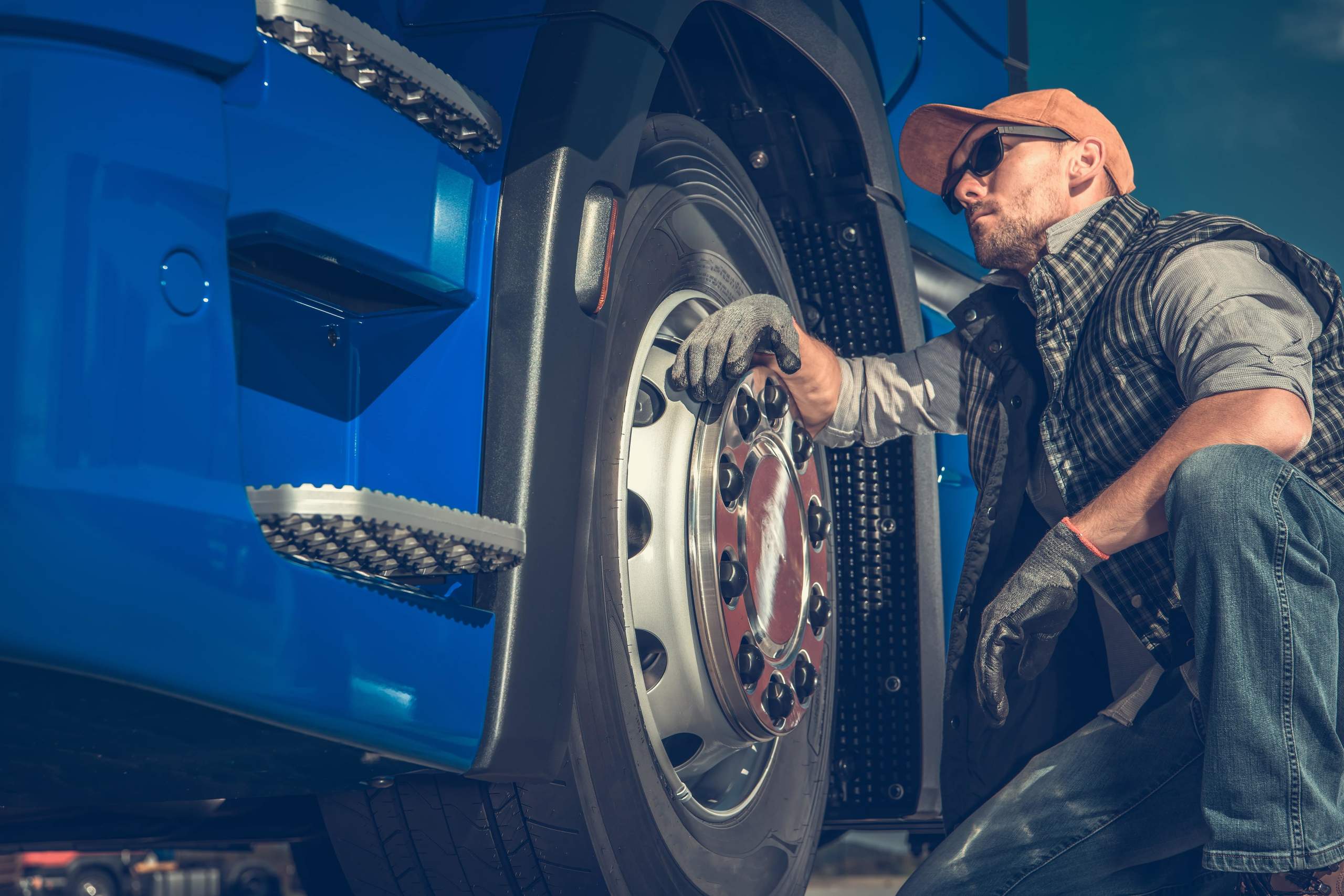 Driver checks the condition of truck tyres